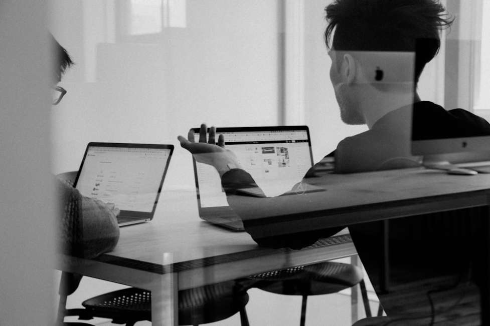 two people working together looking at their computers 