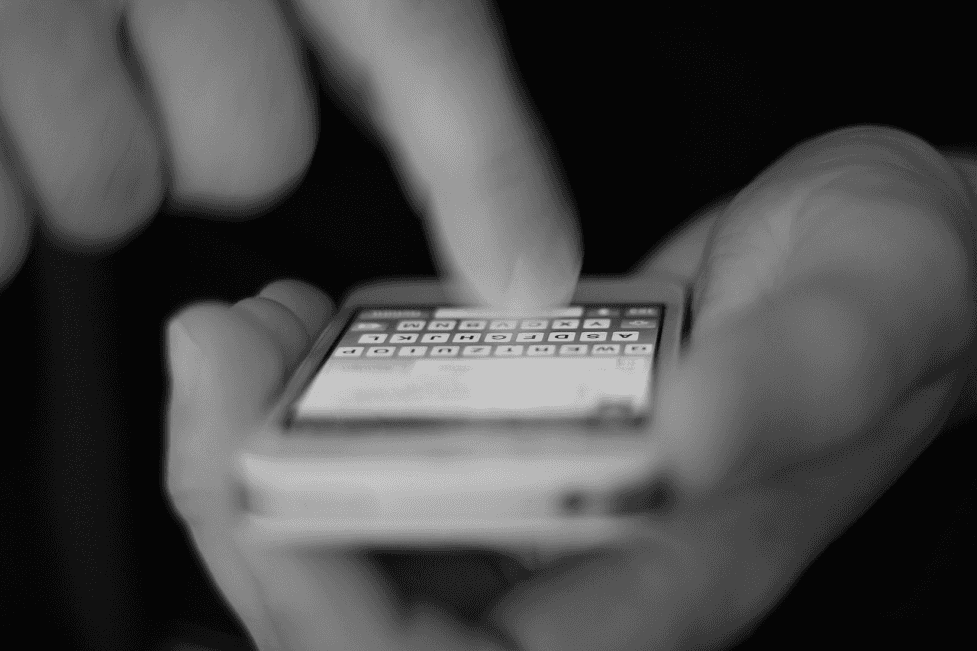 stock image of a person sending a message via an mobile phone 