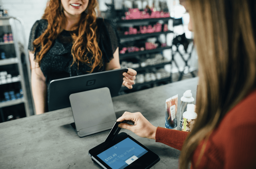 stock image of a woman paying at the cashier at a shop 