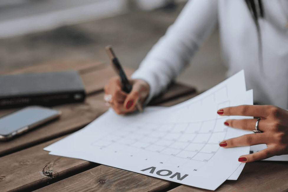 stock image of a woman working on a paper calendar 