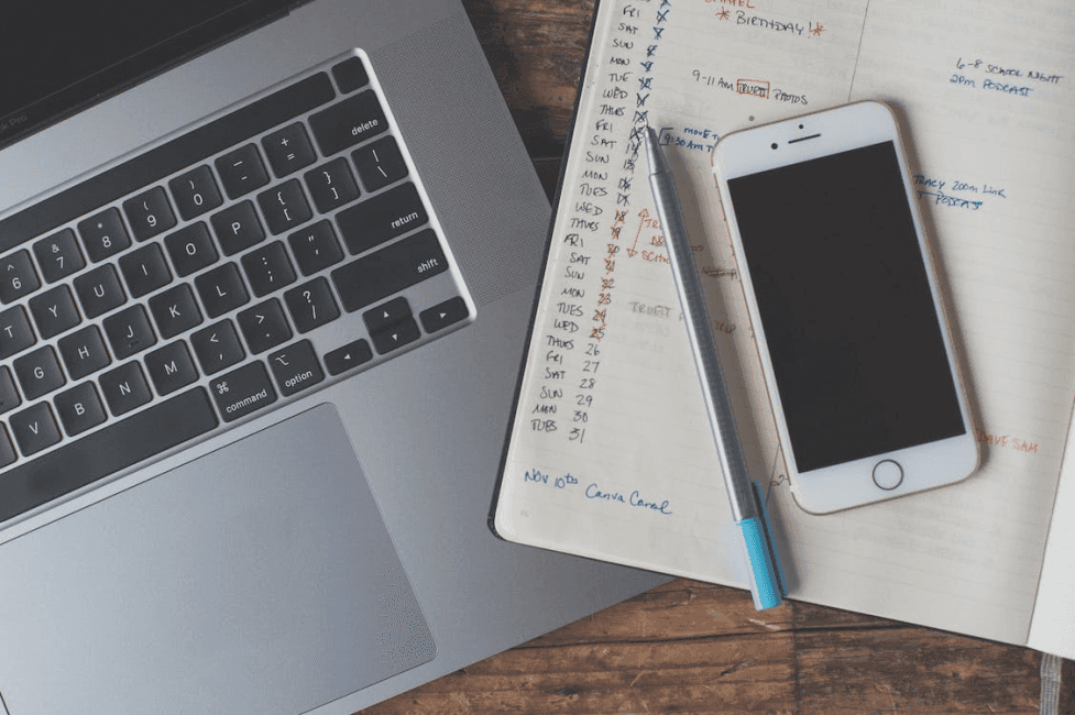 stock image of a computer and a notebook next to it 