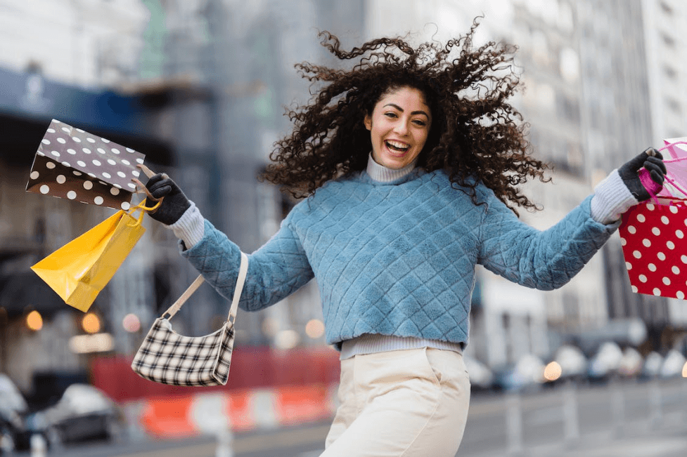 stock image of a happy woman with myna shopping bags 